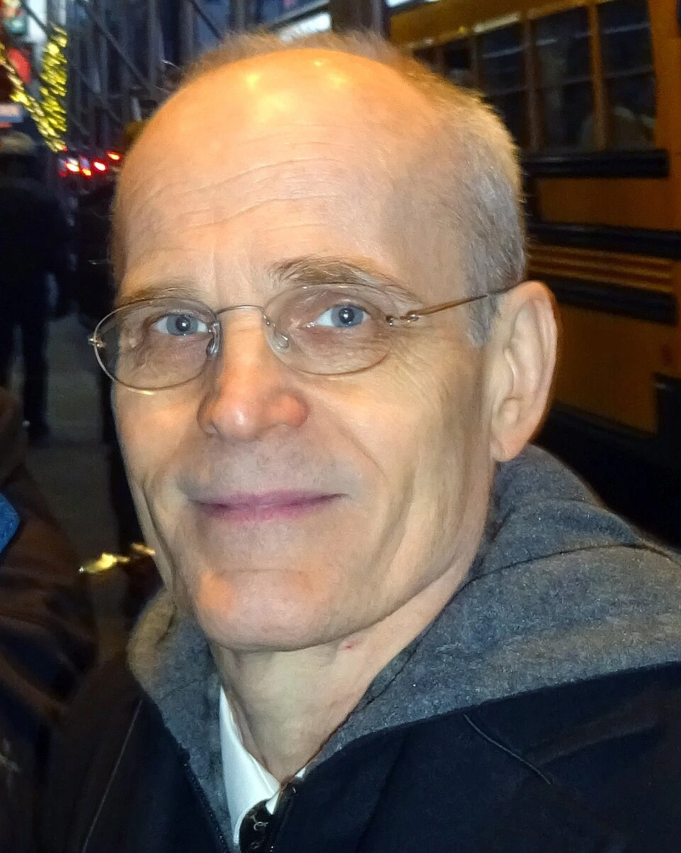 Portrait of Željko Ivanek wearing glasses outdoors at night