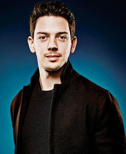 Portrait of Milun Tesovic against a blue background