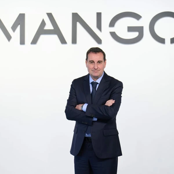 Isak Andic standing in a suit in front of a Mango backdrop