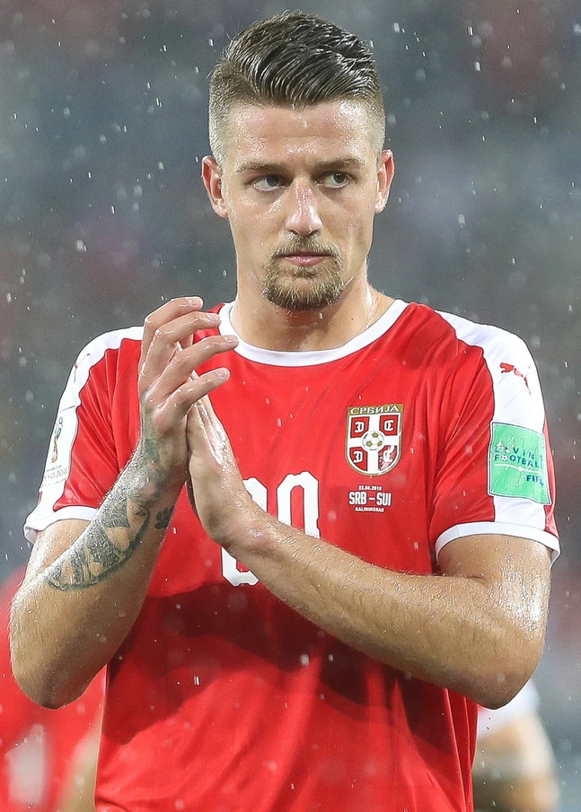 Sergej Milinković-Savić in a Serbia national team match, clapping in the rain.